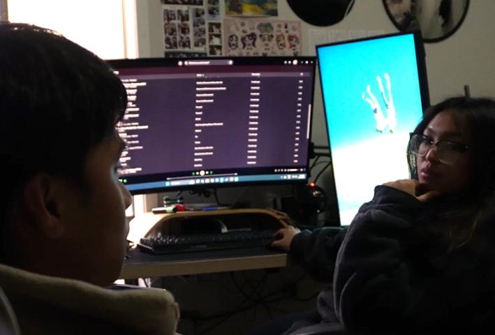 Two women talking in front of computer screens