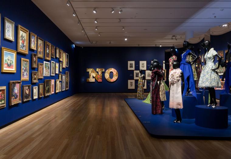 Image showing inside the Floribunda art exhibition with dresses on one side, prints on the other. 