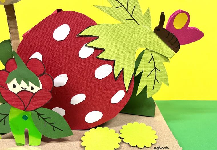 a paper strawberry with a butterfly sitting on top