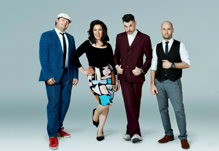 Four musicians stand in a line. 