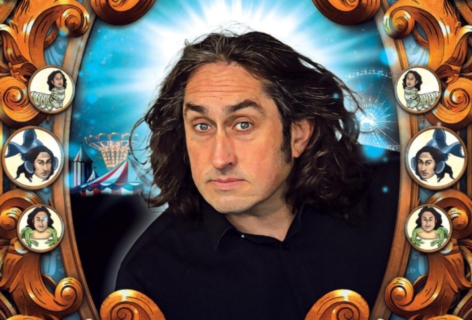 A man with long dark wavy hair looks through a frame that features buttons with his face on creatures - Ross Noble Cranium of Curiosities