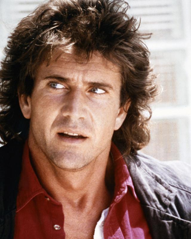 Mel Gibson - a man with a shaggy haircut looks to the side. 